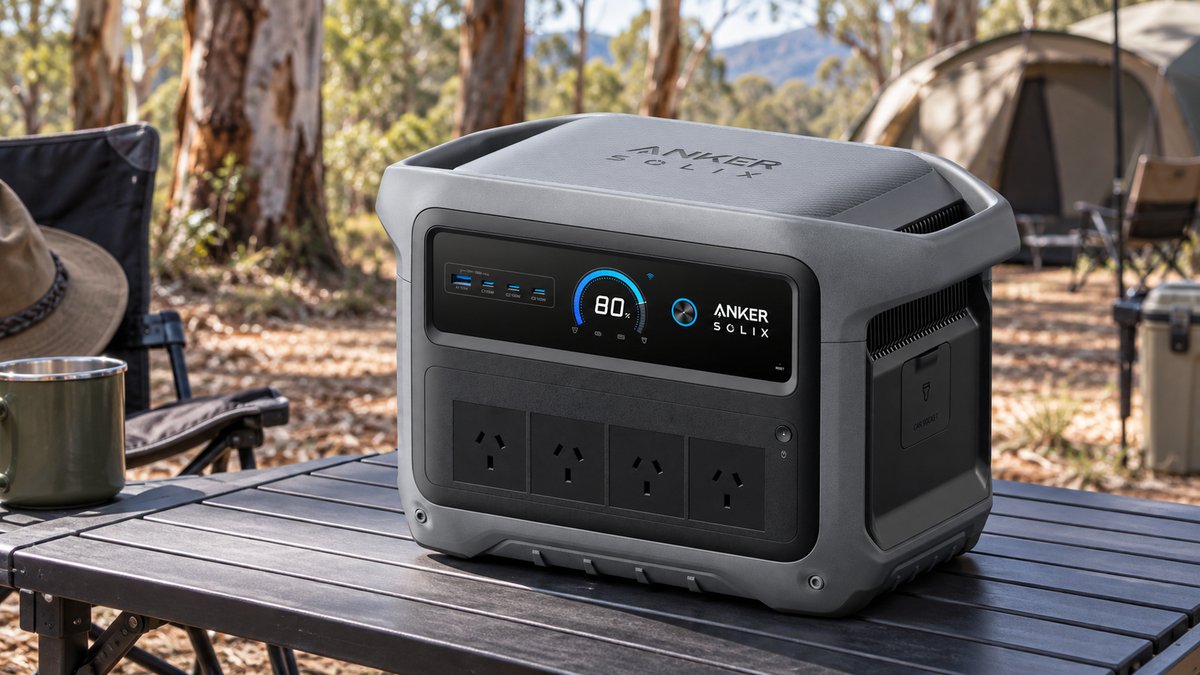 Anker SOLIX C1000 Gen 2 power station on a camping table beside a bush campsite.