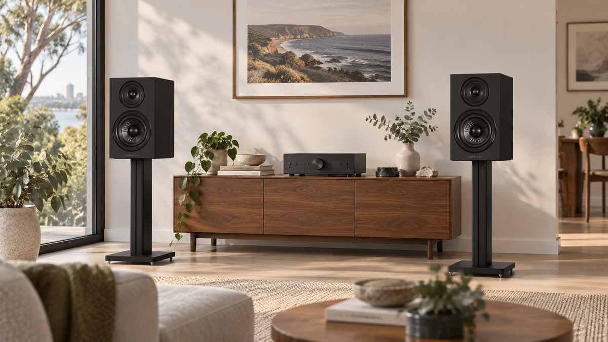Black Wharfedale Diamond 12.2i speakers on stands beside a walnut cabinet and stereo amplifier.
