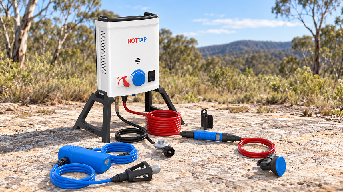 Joolca HOTTAP V2 Outing Kit heater, pump and shower hoses arranged on a stone surface at an outdoor campsite.